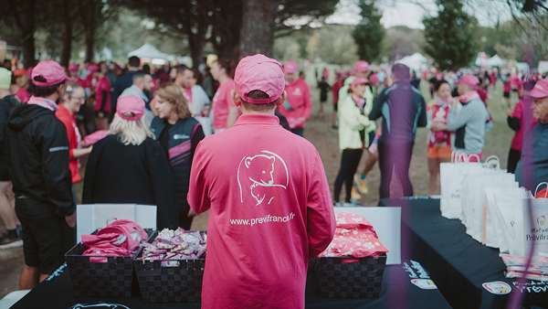 Homme habillé en rose devant un stand