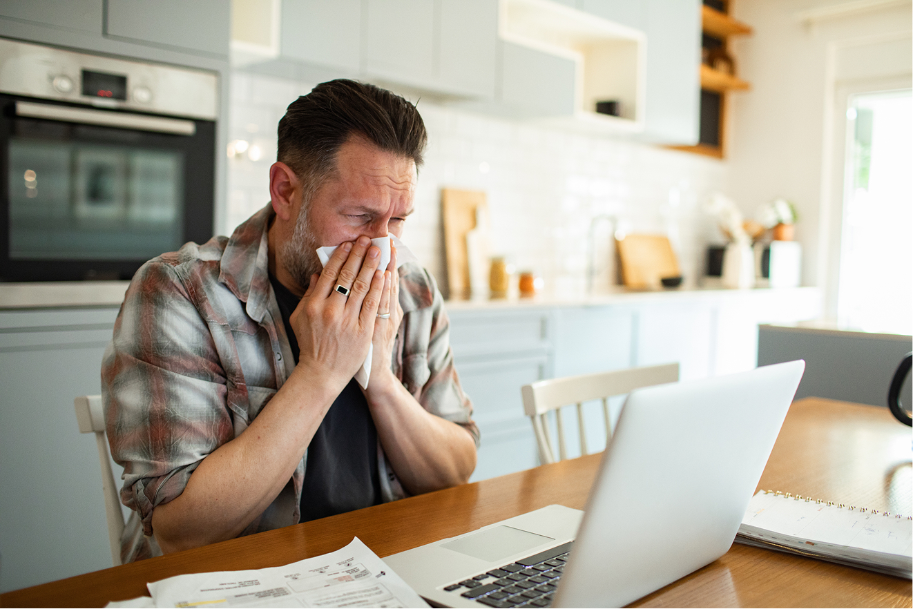 Homme malade qui se mouche en arret de travail avec sa mutuelle d'entreprise