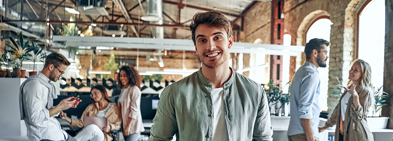 Homme en chemise souriant, face caméra dans une startup