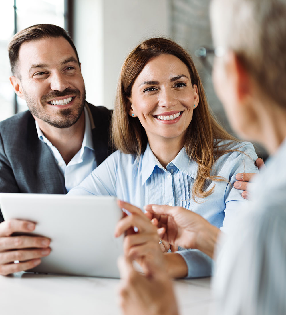 Couple souriant avec agent immobilier