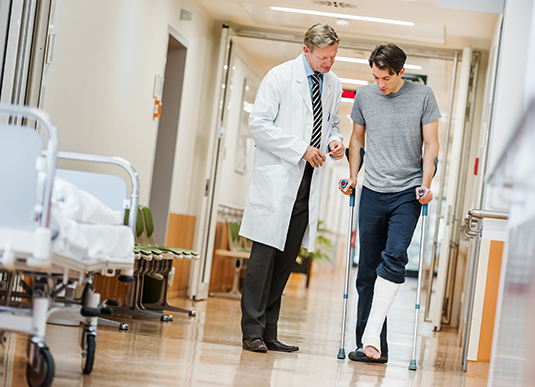 Homme avec béquilles dans un hôpital avec un médecin