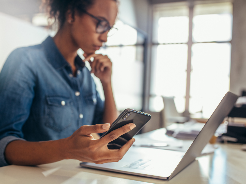 Femme consultant son ordinateur et son téléphone portable